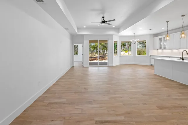a view of an empty room with window and wooden floor