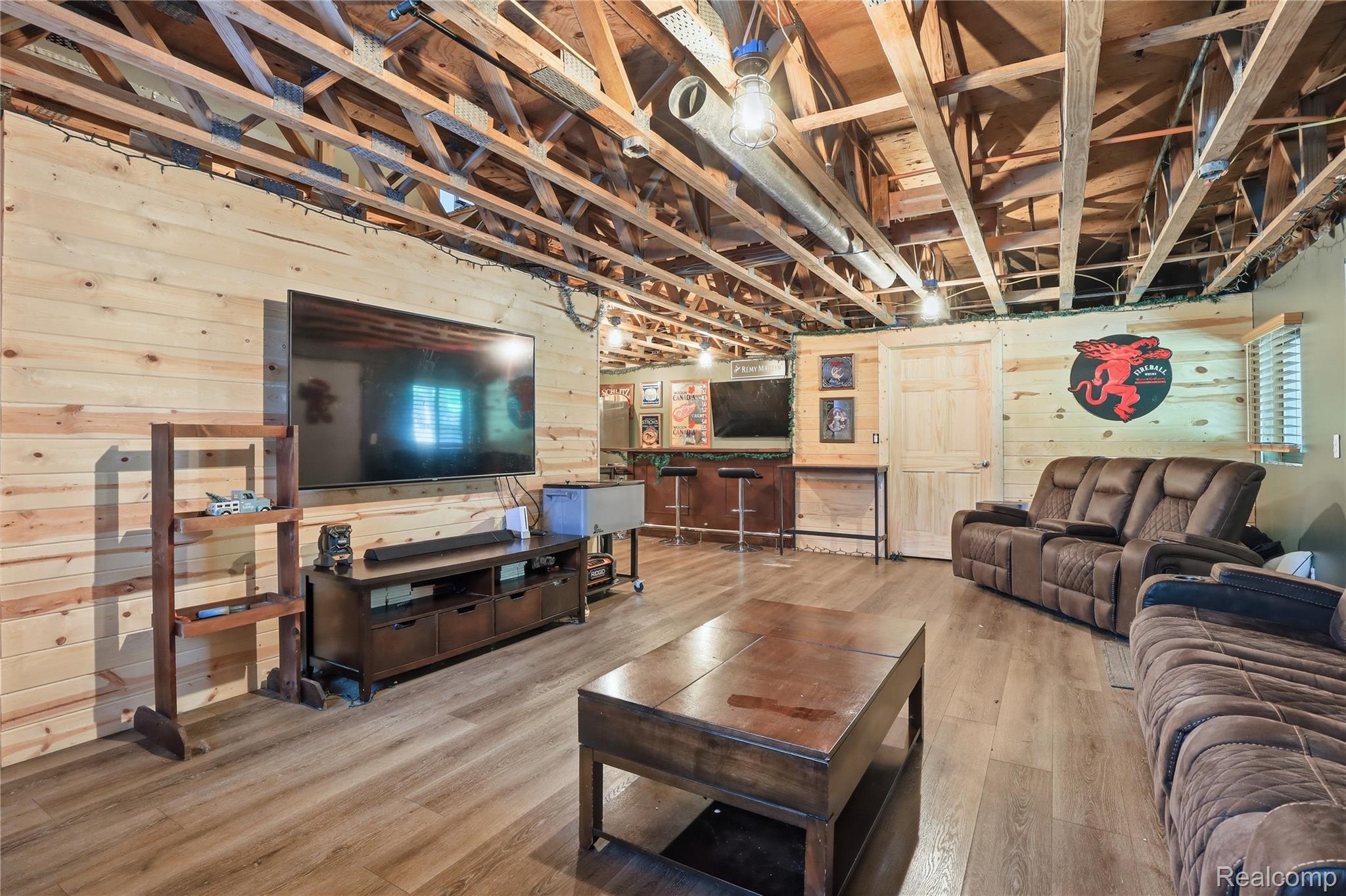 14830 Sheridan Road Byron, MI 48418 - Photo 36 of 74 Wood-finish flooring throughout a spacious room with exposed ceiling joists
