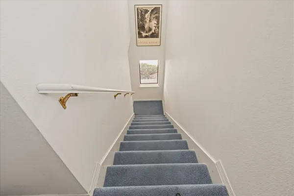 a view of staircase with wooden floor and white walls