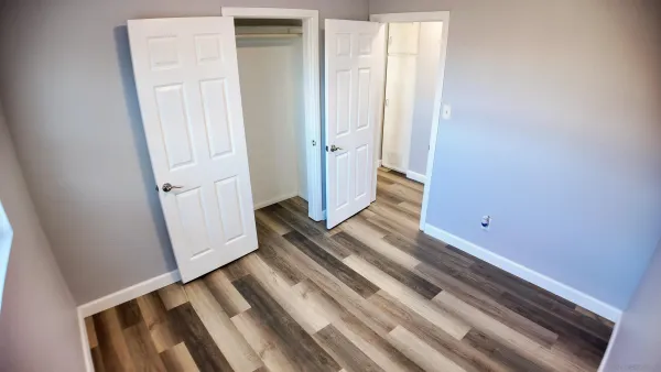 a view of a room with wooden floor and white walls
