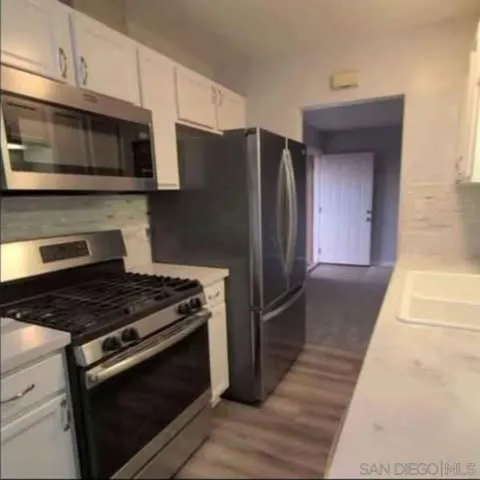 a kitchen with stainless steel appliances granite countertop a stove microwave and refrigerator