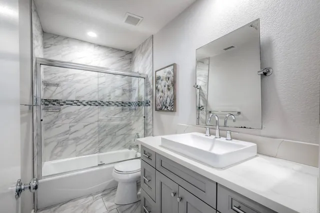 a large bedroom with a bed and a chandelier