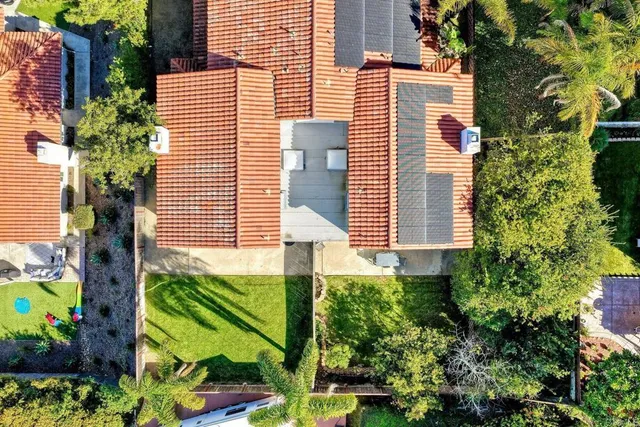 a view of a house with a yard and a large tree
