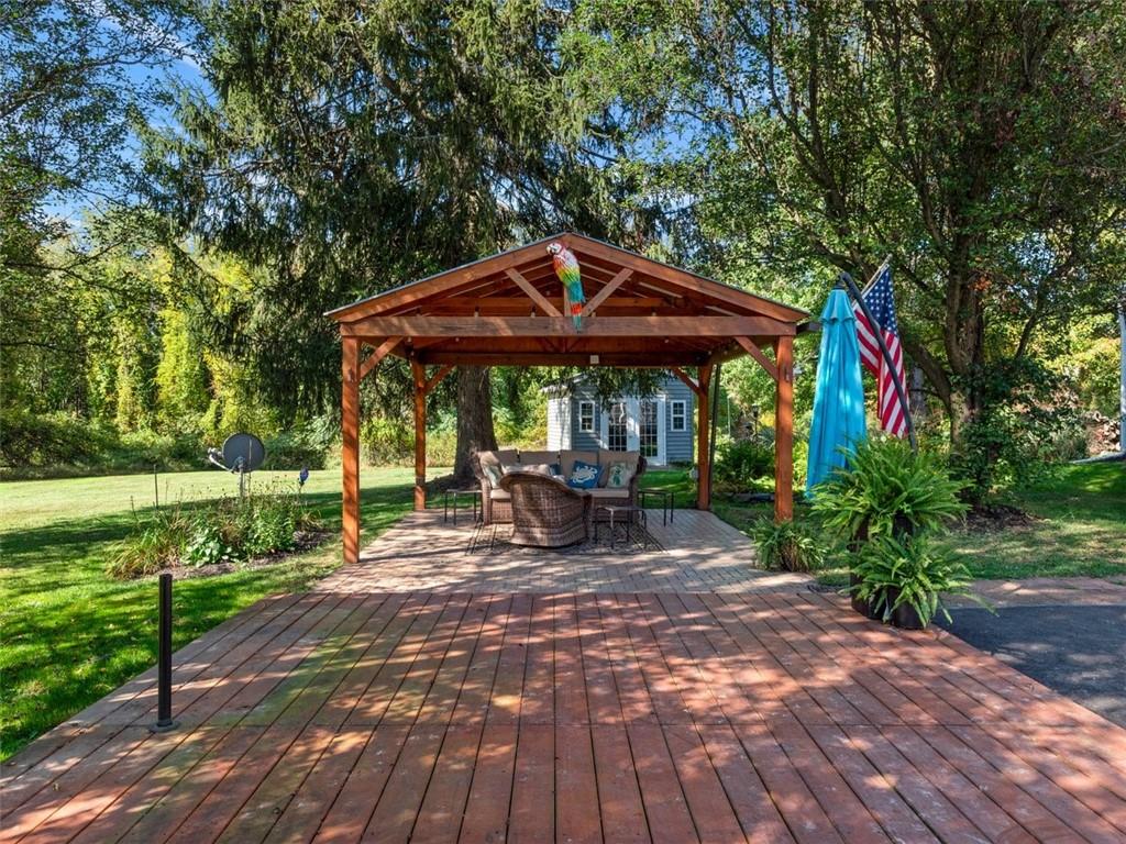 360 Dappenbrook Drive Beaver, PA 15009 - Photo 25 of 30 a view of a patio with table and chairs under an umbrella with wooden floor