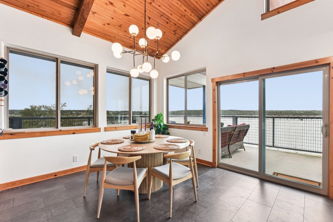 1813 Graveyard Point Road Austin, TX 78734 - Photo 12 of 40 a dining room with wooden floor a chandelier a glass table and chairs