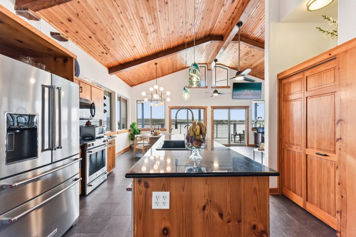 1813 Graveyard Point Road Austin, TX 78734 - Photo 6 of 40 a kitchen with stainless steel appliances granite countertop a sink a stove and refrigerator