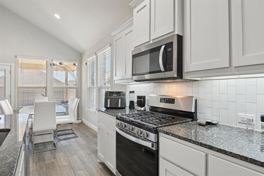 1504 Rachel Street Northlake, TX 76247 - Photo 13 of 40 a kitchen with stainless steel appliances granite countertop a stove microwave and cabinets