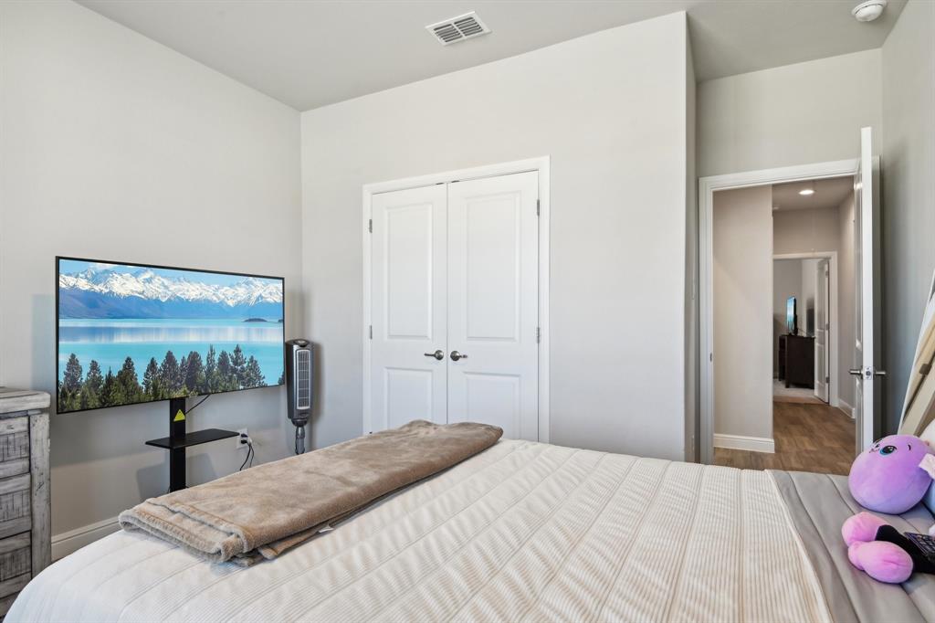 1504 Rachel Street Northlake, TX 76247 - Photo 20 of 40 a bedroom with a bed and a flat screen tv