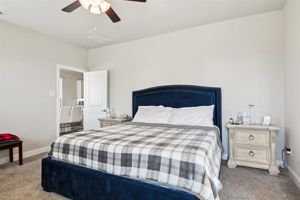 1504 Rachel Street Northlake, TX 76247 - Photo 29 of 40 a bedroom with a large bed and a chandelier
