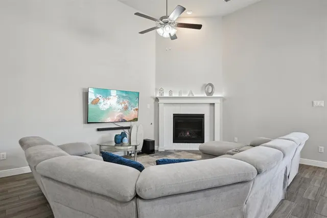 a living room with furniture a fireplace and a flat screen tv