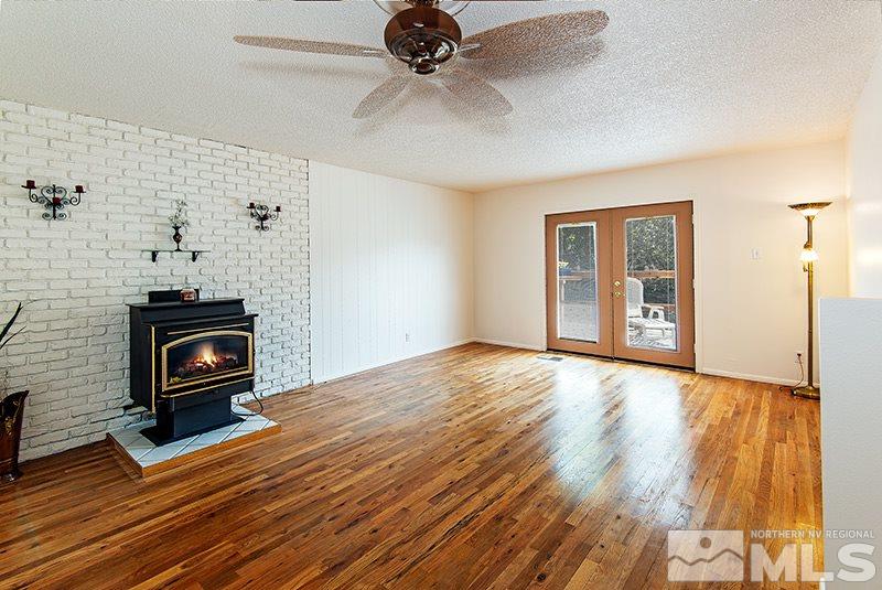 3480 Pierremont Road Reno, NV 89503 - Photo 2 of 16 a view of empty room with wooden floor fireplace and chandelier