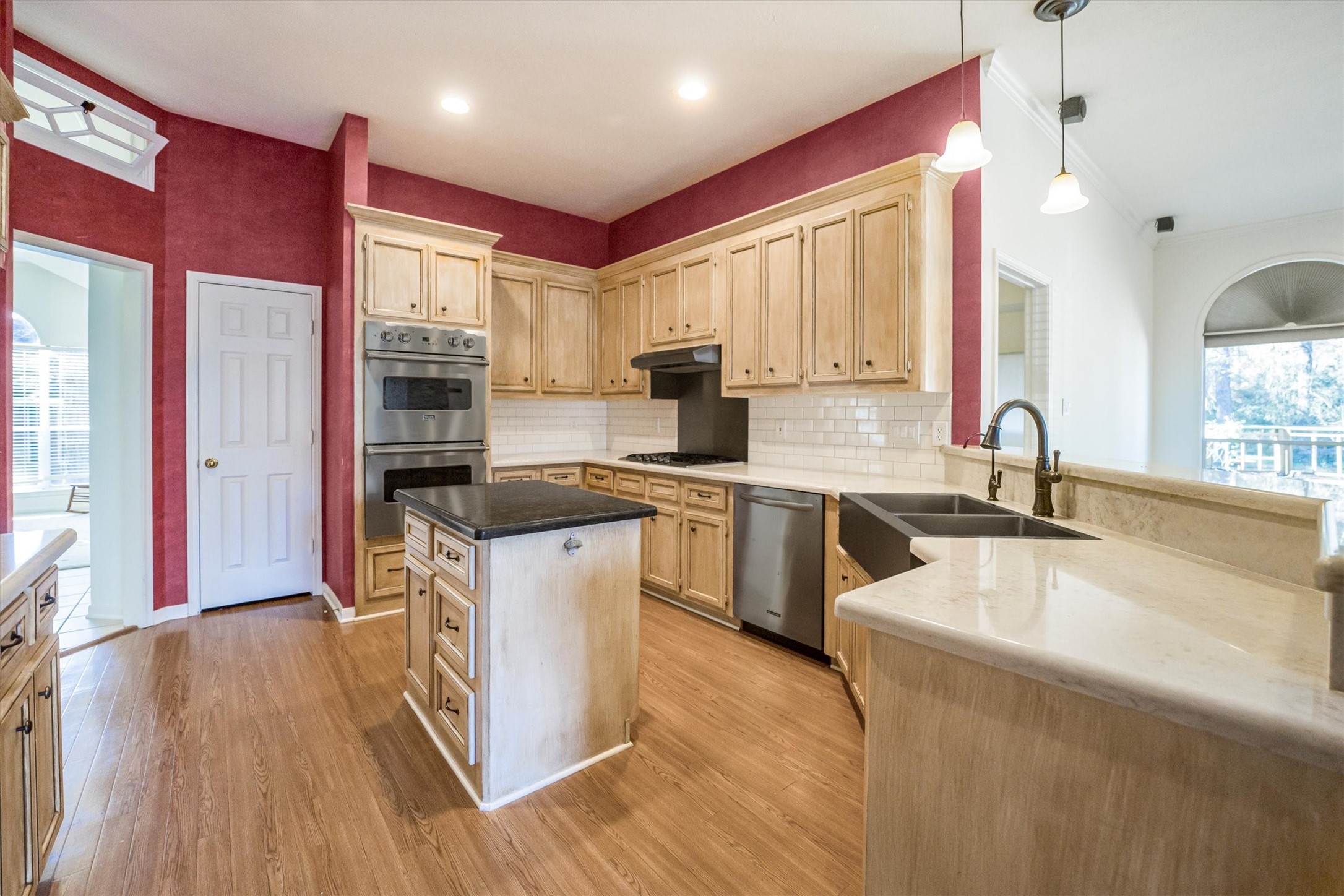 2434 Pebblebrook Circle Conroe, TX 77384 - Photo 12 of 44 a kitchen with stainless steel appliances granite countertop a sink cabinets and wooden floor
