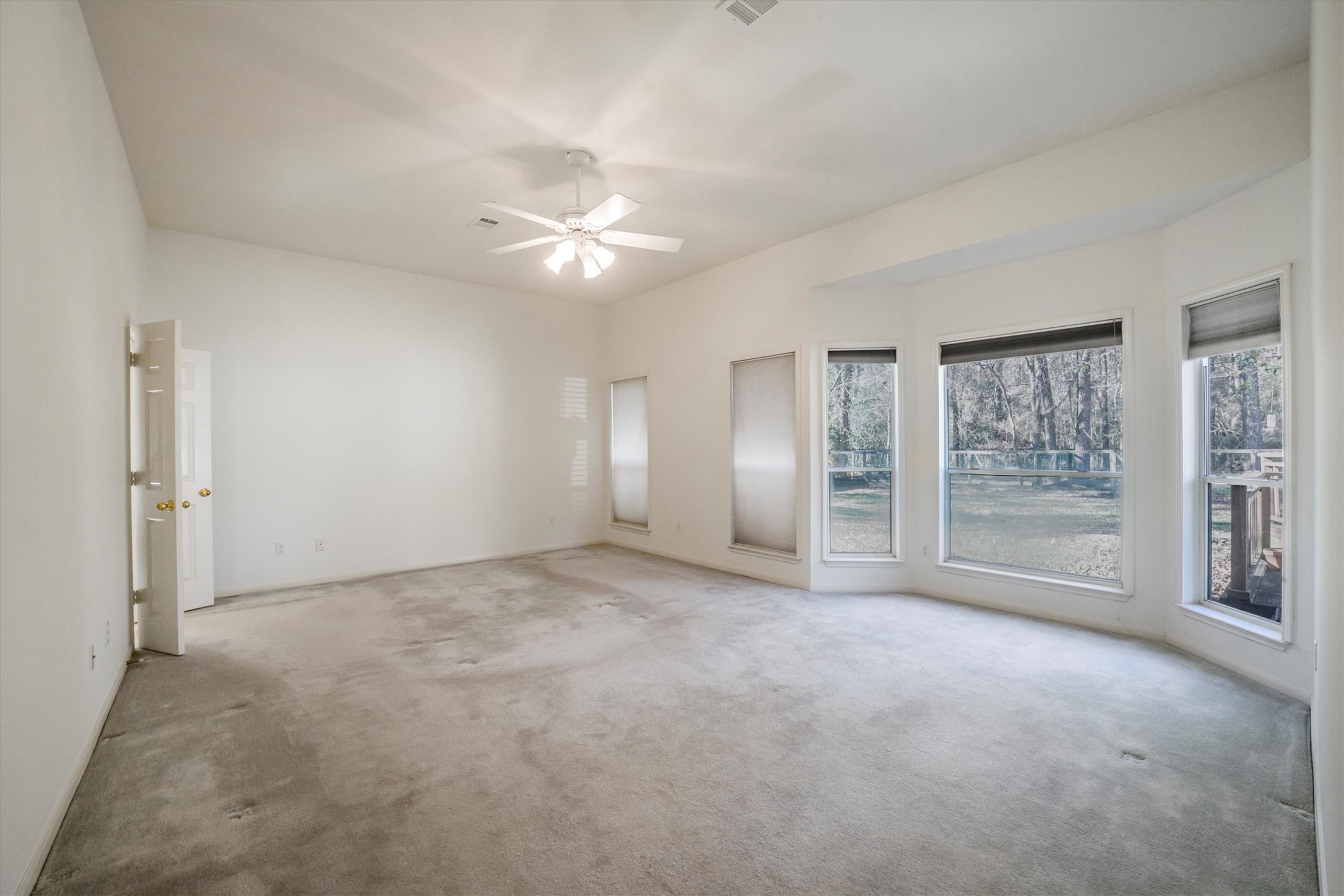 2434 Pebblebrook Circle Conroe, TX 77384 - Photo 22 of 44 an empty room with chandelier fan and windows