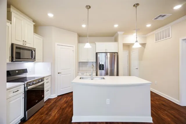 a kitchen with a sink window and stainless steel appliances