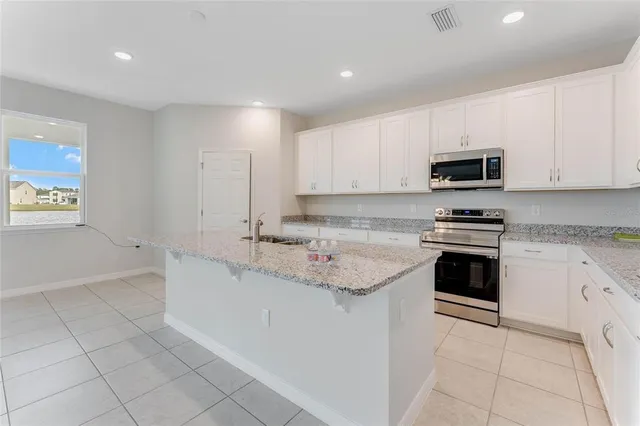 a kitchen with granite countertop a sink and a stove top oven