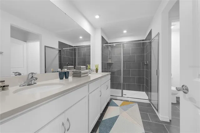 a bathroom with a shower sink and mirror