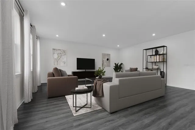 a living room with furniture a flat screen tv and a refrigerator