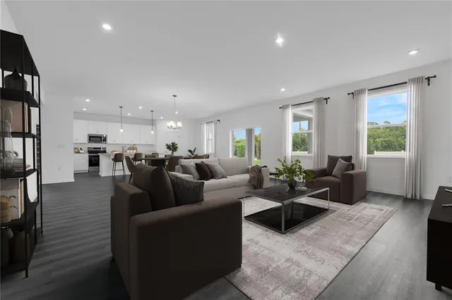 a living room with furniture wooden floor and a large window