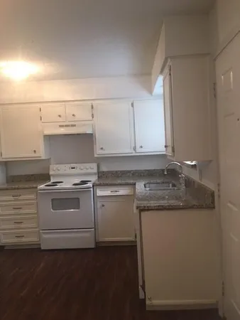 a white stove top oven sitting inside of a kitchen