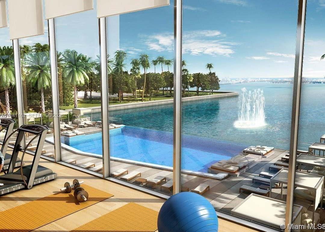 460 Northeast 28th Street, Unit 1907 Miami, FL 33137 - Photo 7 of 7 a room with gym equipment and a table