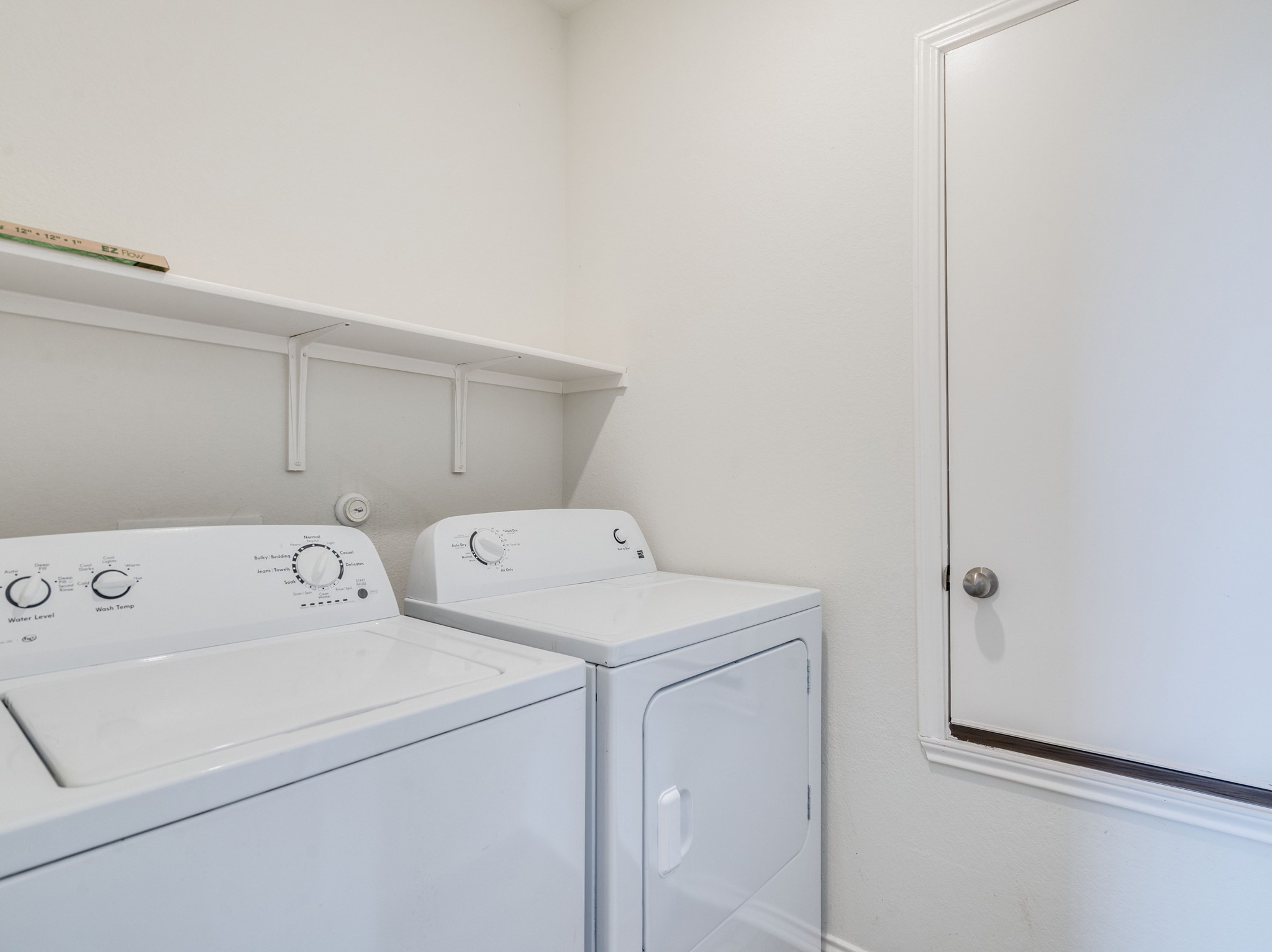 790 Pepperbark Loop Buda, TX 78610 - Photo 18 of 22 A well-appointed laundry area features a practical shelf for organization.