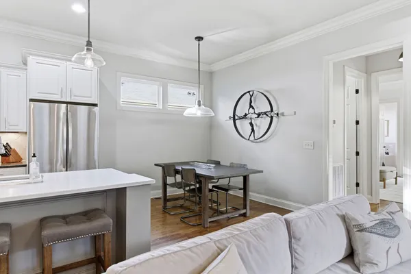 a kitchen with stainless steel appliances granite countertop a sink a stove a refrigerator cabinets and chairs
