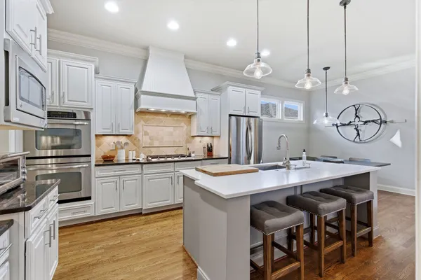 a kitchen with granite countertop a sink a stove and cabinets