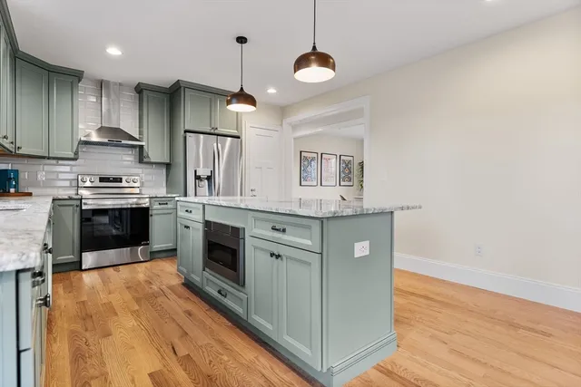 a kitchen with stainless steel appliances granite countertop a stove a sink and a refrigerator