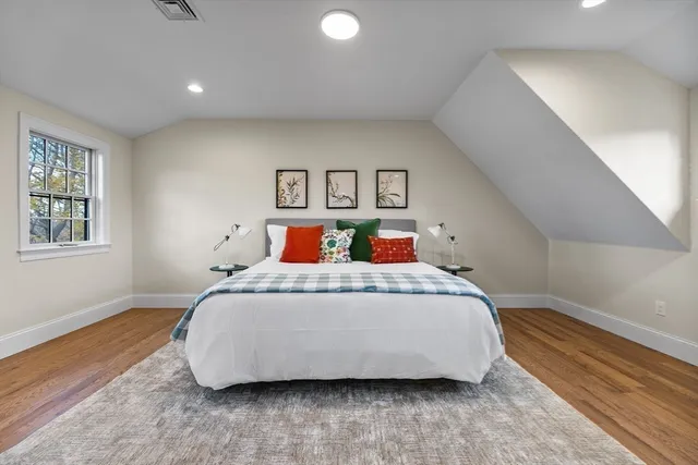 a bedroom with a bed and wooden floor
