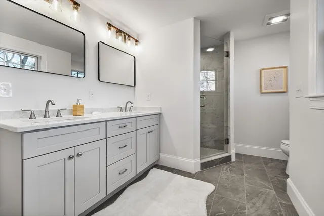 a spacious bathroom with a double vanity sink a mirror and a