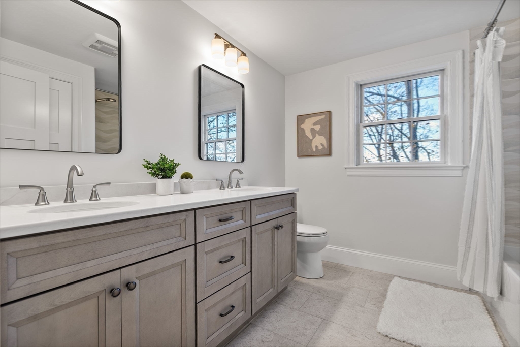 37 Lantern Lane Braintree, MA 02184 - Photo 32 of 40 a bathroom with a double vanity sink a toilet and a window