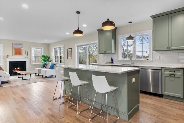 a kitchen with granite countertop a stove a sink a dining table and chairs