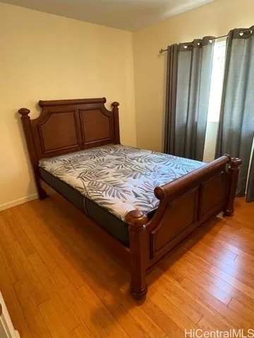 a bedroom with a bed and wooden floor