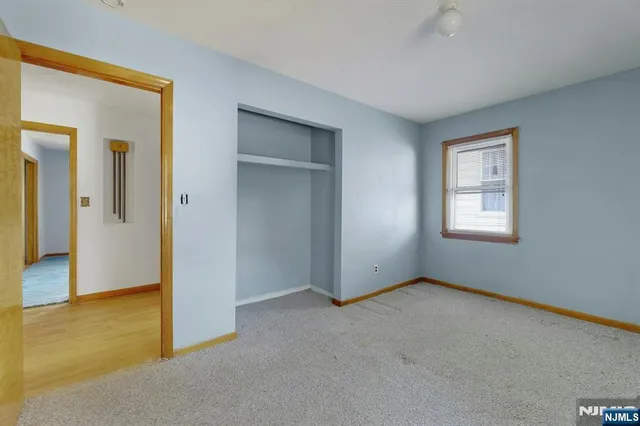 an empty room with windows and closet