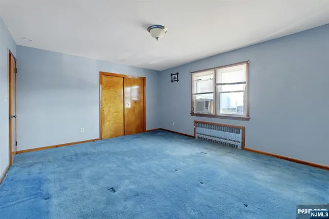 an empty room with windows and closet