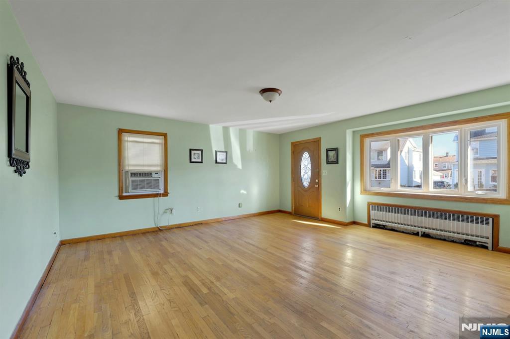 835 Chestnut Street Kearny, NJ 07032 - Photo 4 of 26 a view of an empty room with wooden floor and a window