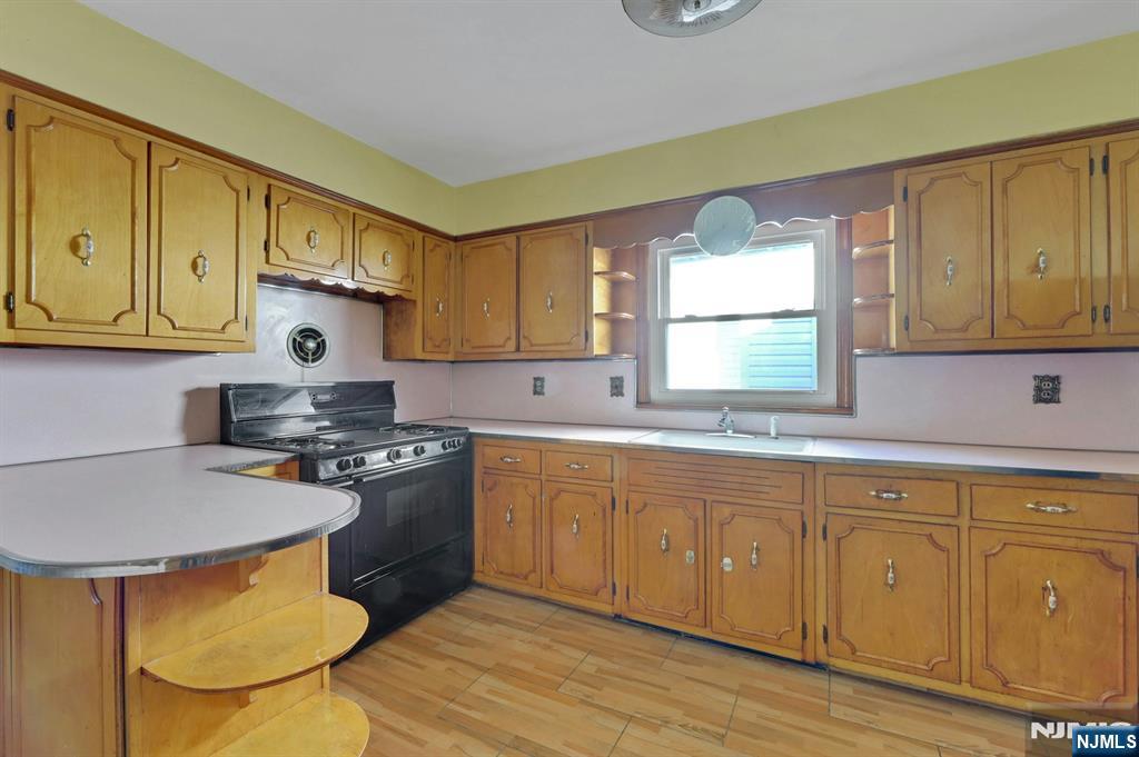 835 Chestnut Street Kearny, NJ 07032 - Photo 6 of 26 a kitchen with stainless steel appliances granite countertop a sink a stove a refrigerator cabinets and dining table