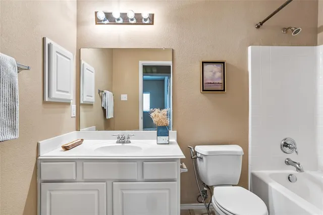 a bathroom with a sink mirror vanity and toilet
