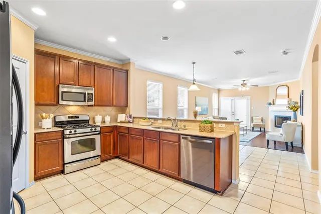 a kitchen with stainless steel appliances granite countertop a stove top oven a sink dishwasher and a refrigerator