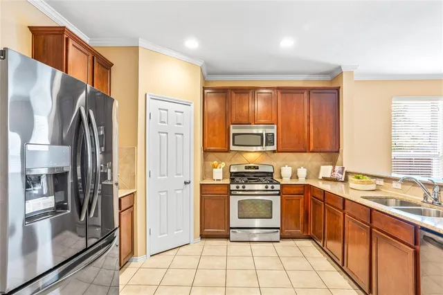 a kitchen with stainless steel appliances granite countertop a refrigerator stove and sink