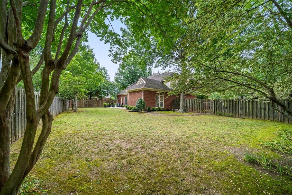 1876 Liles Lane Collierville, TN 38017 - Photo 26 of 36 Spacious backyard featuring a wooden privacy fence and mature trees