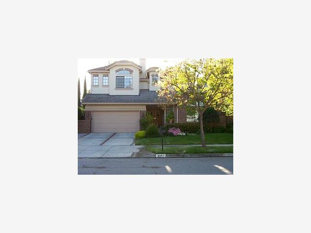 a picture of a bench in front of a house
