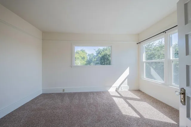 a kitchen with stainless steel appliances kitchen island granite countertop a refrigerator a sink dishwasher and white cabinets with wooden floor