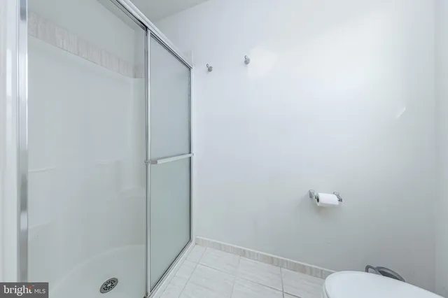a bathroom with a granite countertop toilet and a shower
