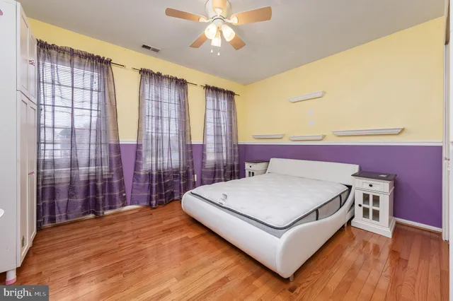 a spacious bedroom with a large bed and a chandelier