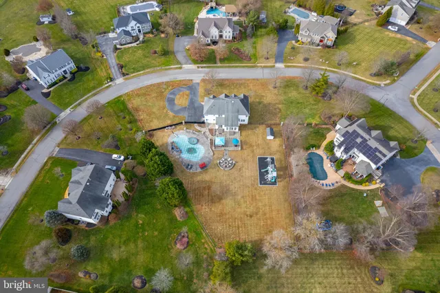 an aerial view of a house with swimming pool and lake view