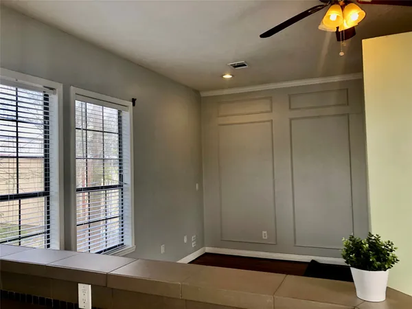 a view of an empty room with window and cabinet area