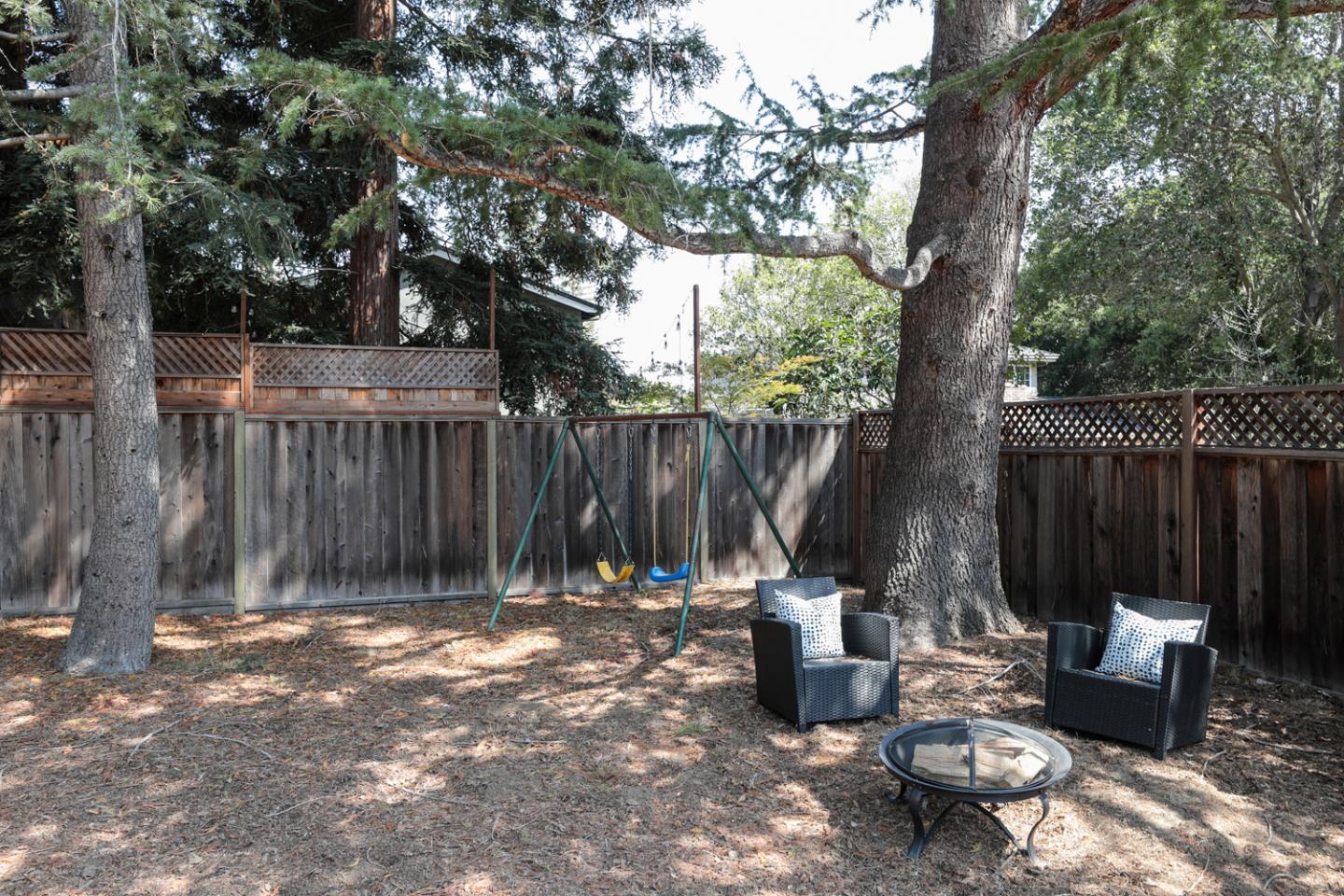 349 Chamisal Avenue Los Altos, CA 94022 - Photo 22 of 27 a view of a backyard with two chairs and a large tree