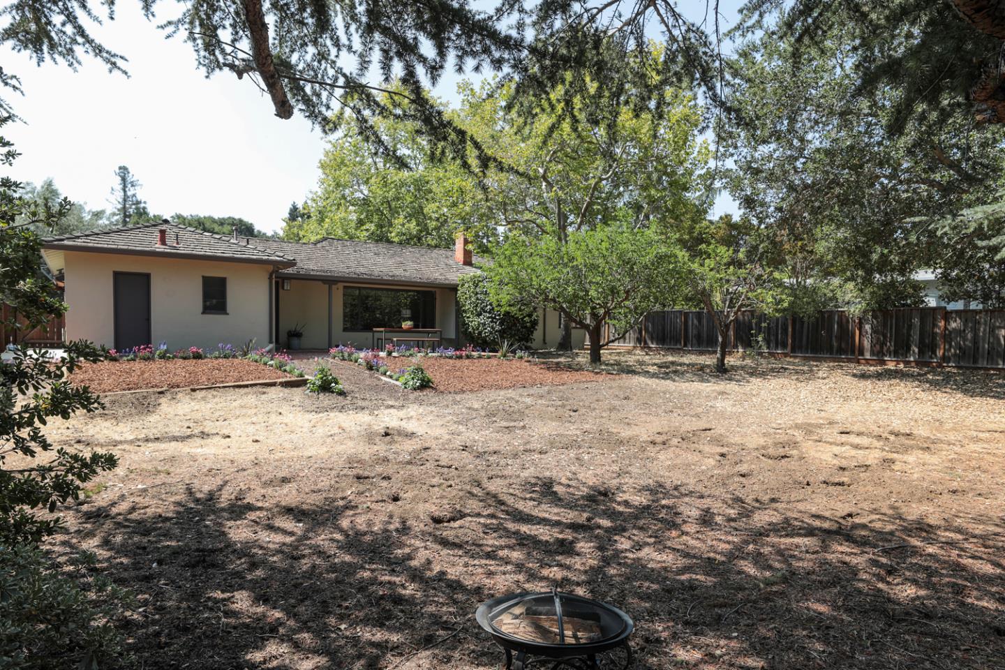349 Chamisal Avenue Los Altos, CA 94022 - Photo 23 of 27 a backyard of a house with table and chairs under an umbrella