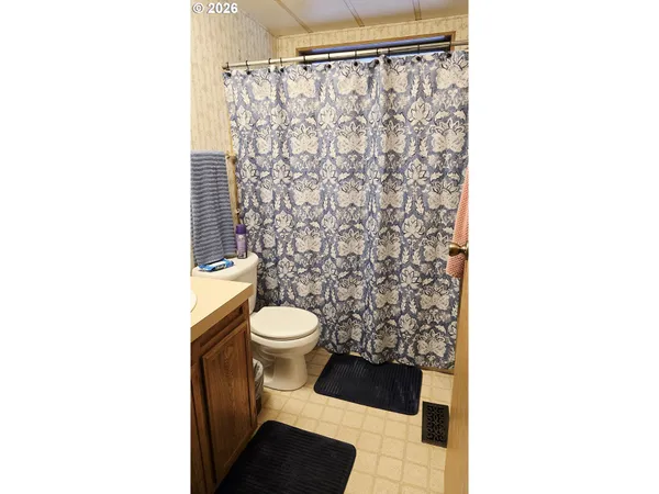 a bathroom with a toilet and a shower curtain